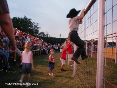 Eager Wimberley children climb fence...
